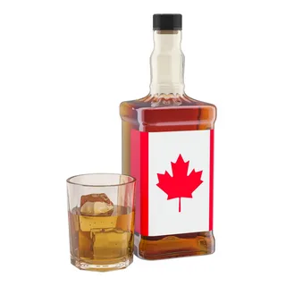 Bottle of Canadian whiskey with a maple leaf label beside a glass of whiskey, representing iconic alcoholic drinks of Canada discussed in the article