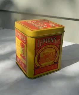 A vintage yellow Lipton’s tea tin, symbolizing the historical roots of ancient tea traditions and the long aging process of teas like Pu-erh from old tea trees.