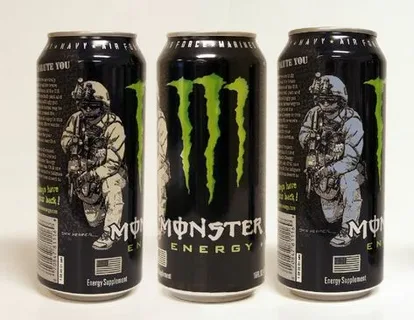 Three standard 16 oz Monster Energy cans standing upright, showing the typical height and design referenced in the article section about standard can size